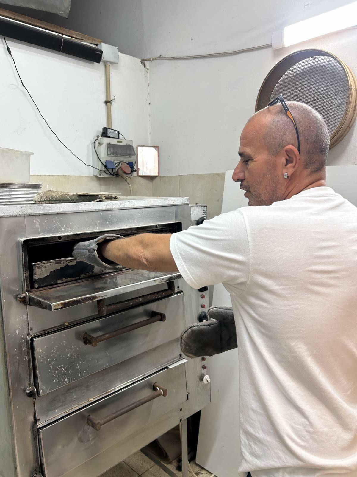 יוסי נדב ליד התנור הישן שבו נקלים הפיצוחים